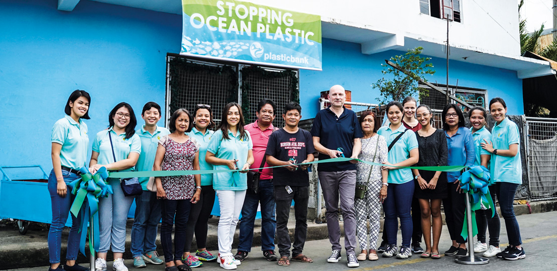 Plastic Bank team members cutting a green ribbon (photo)